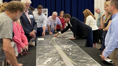 guests examine project plans at an earlier open house meeting